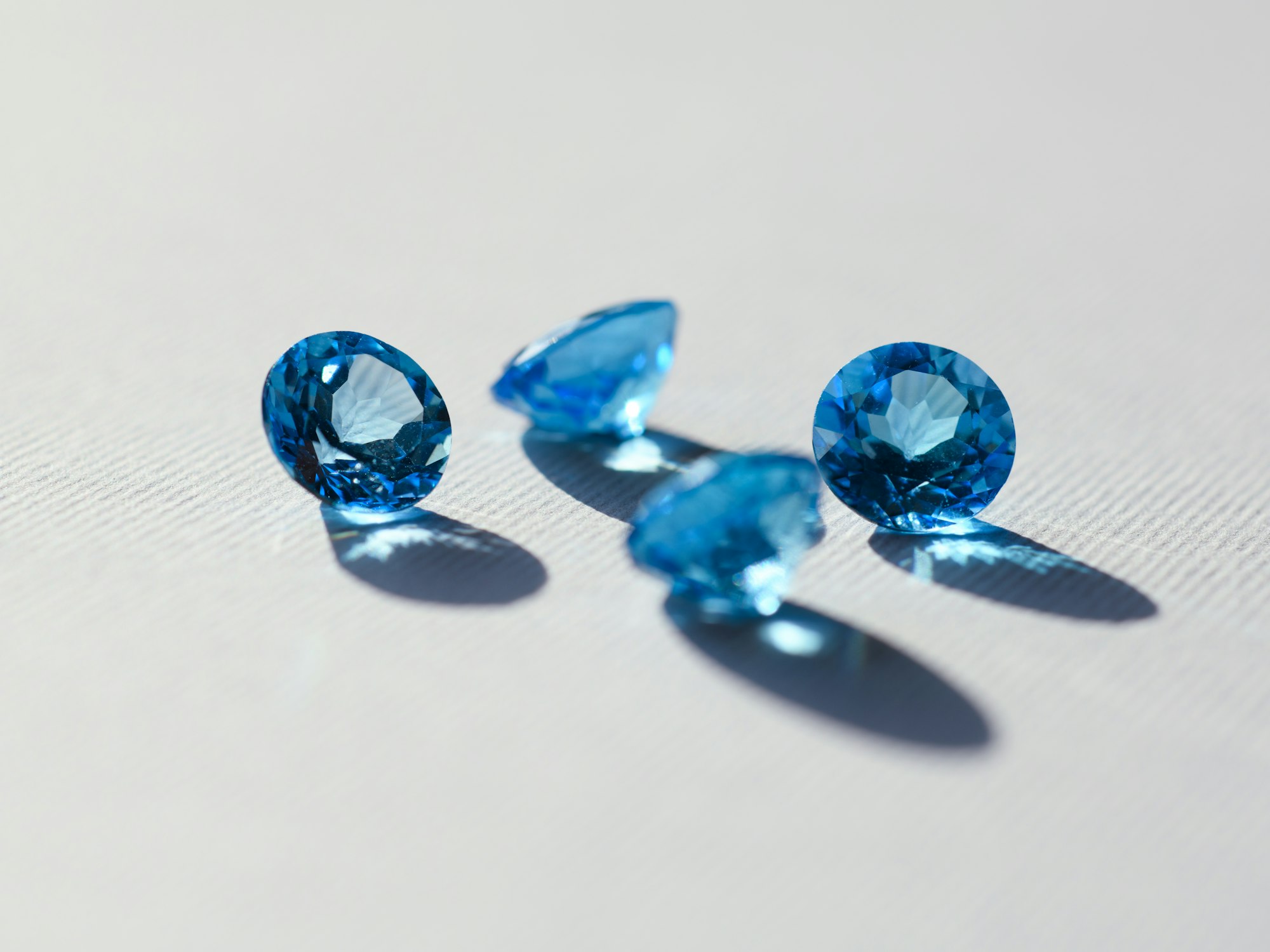 Cut coloured gemstones displayed on a dark surface