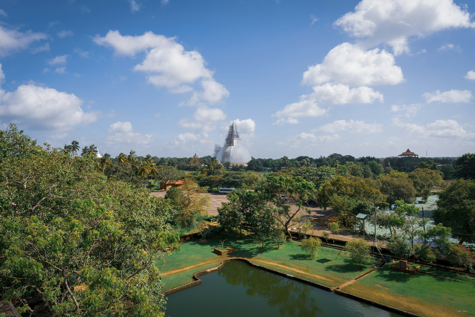 An aerial view of an ancient temple pond ringed by trees